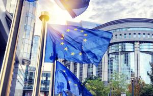 EU flags waving in front of European Parliament building in Brussels