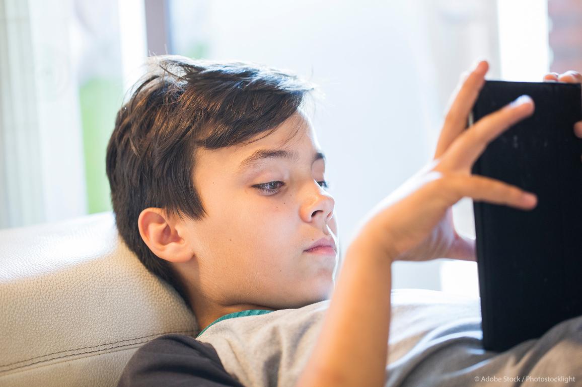 A boy is playing with his tablet